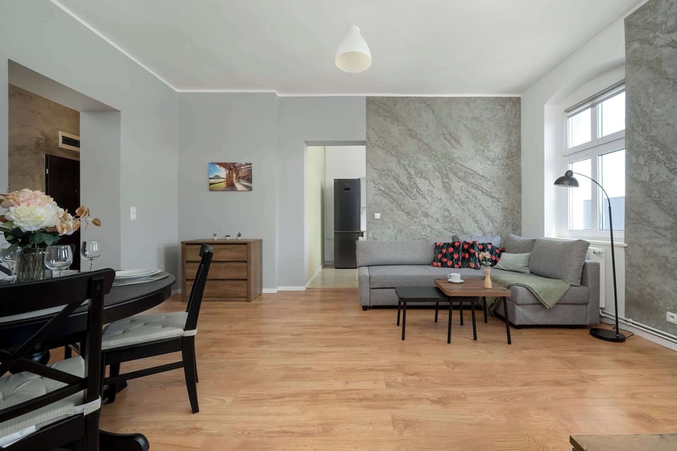 A view of a spacious living room combined with a dining area in minimalist decor.