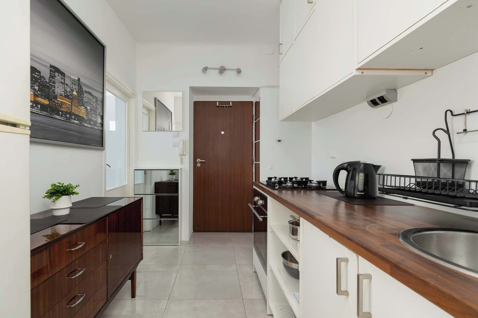 Kitchenette with gas hob, oven, refrigerator with freezer and electric kettle.