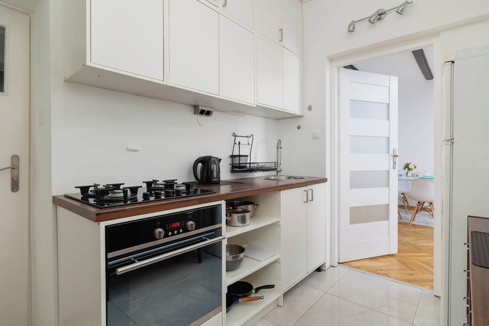 Kitchenette with gas hob, oven, refrigerator with freezer and electric kettle.
