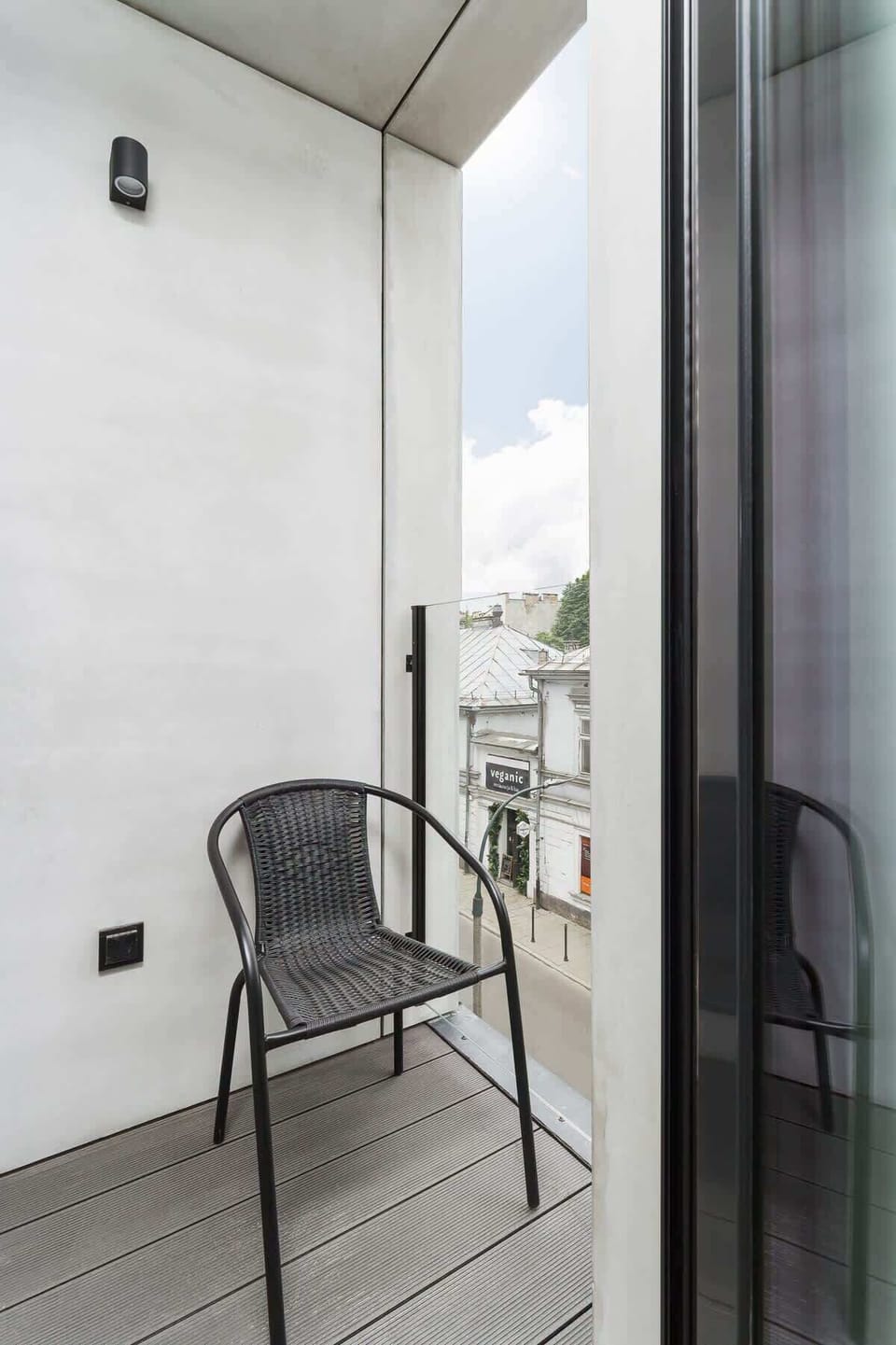 A small balcony with a simple railing and a view of the street below. It’s a compact outdoor space for fresh air and relaxation.