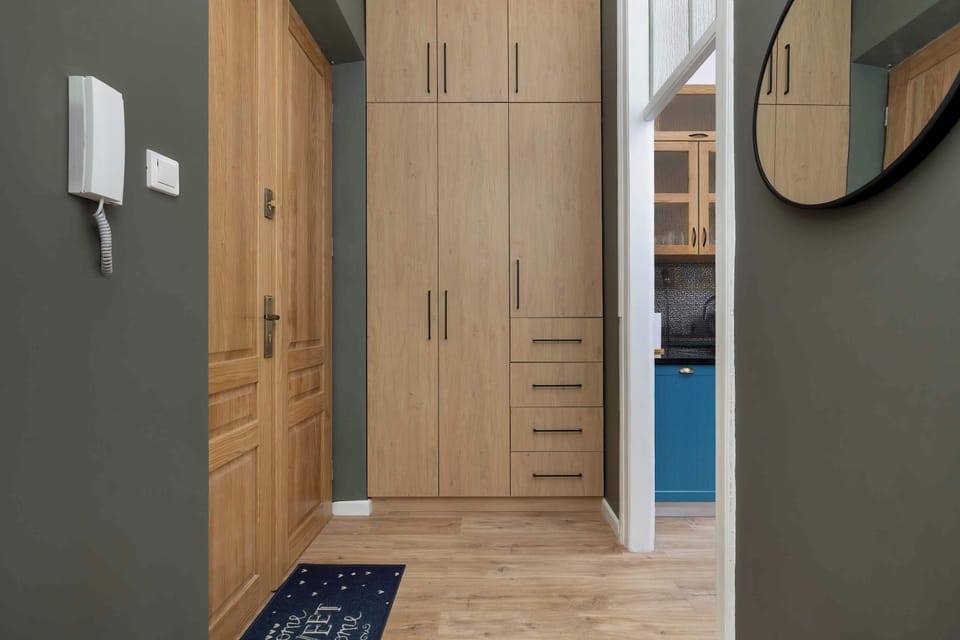 A hallway with wooden doors and built-in storage.
Warm tones and tidy layout create a welcoming transition between rooms.

