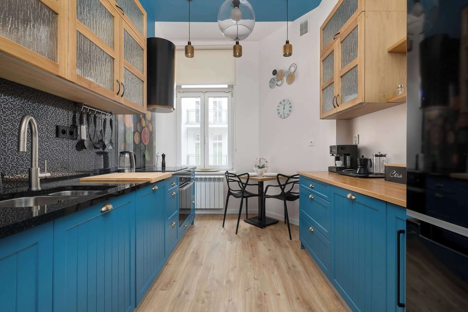 Features modern appliances and a round dining table for cozy meals.

