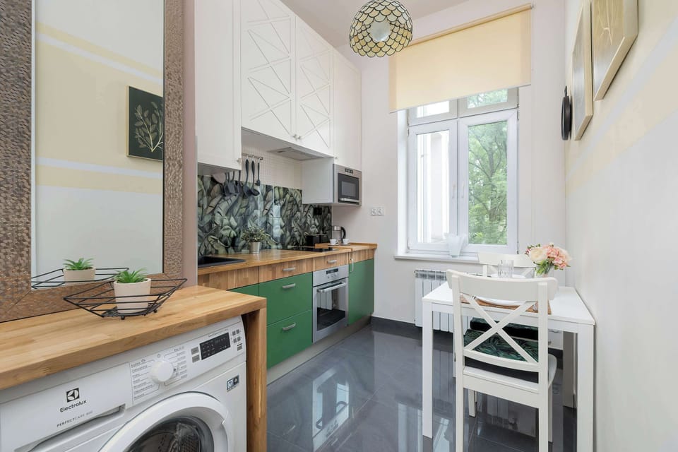 Another angle of the kitchen with a washer and natural light pouring in, showing functionality in a compact space.