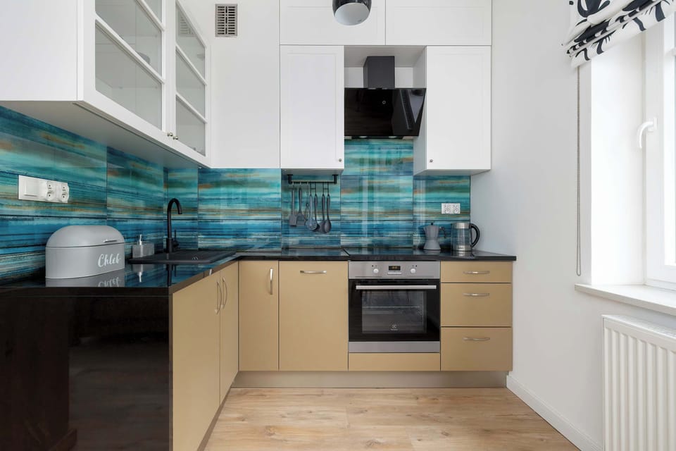 A compact and modern kitchenette with essential appliances and a stylish backsplash, ideal for cooking at home.