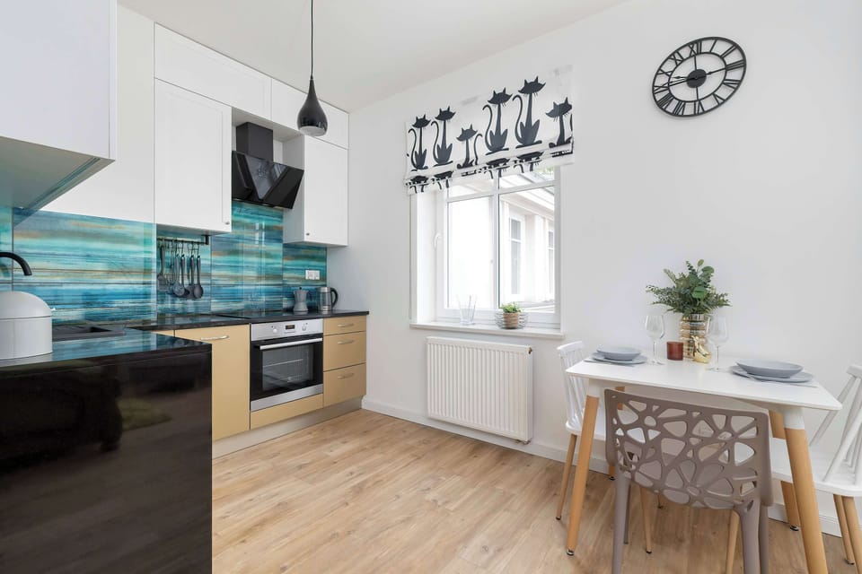 A corner of the modern kitchen with built-in appliances and bright turquoise tiles. Clean, fresh, and easy to maintain