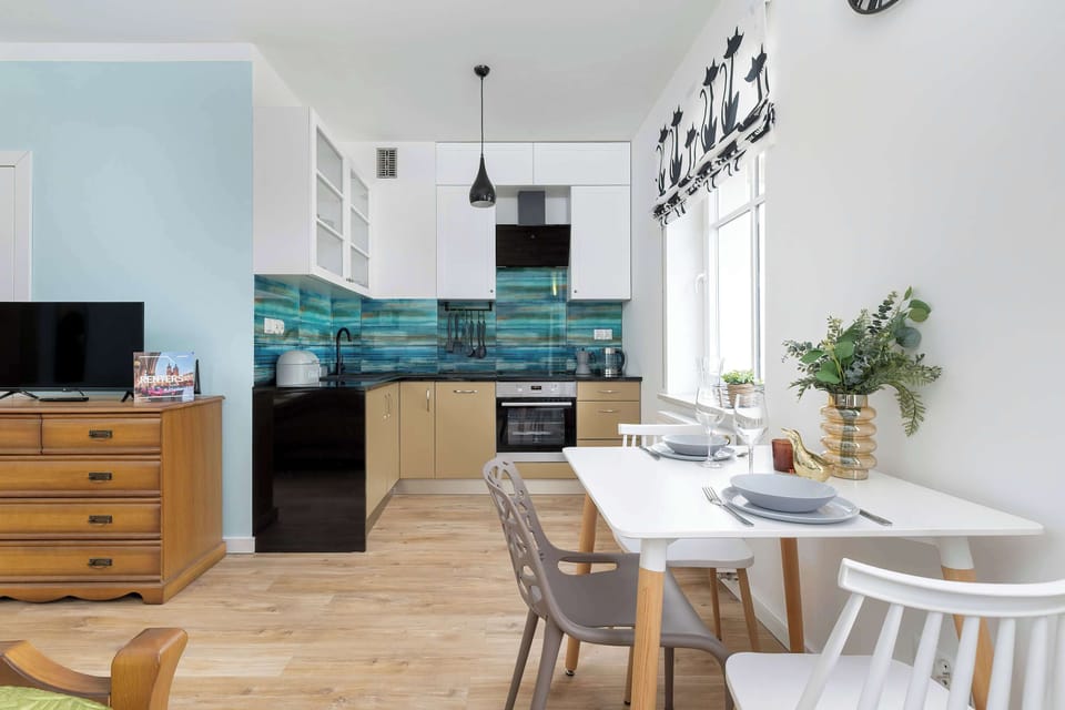 A bright kitchen and dining space with turquoise tiles and wood accents. Perfect for preparing meals and enjoying casual dining at home.