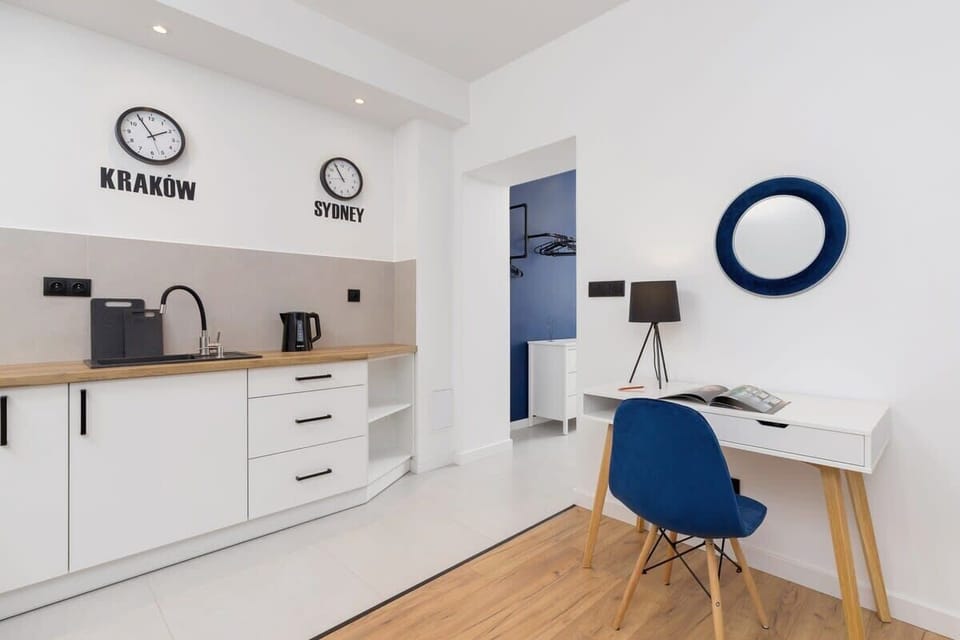 A sleek kitchenette featuring white cabinets, a microwave, and a small workspace.