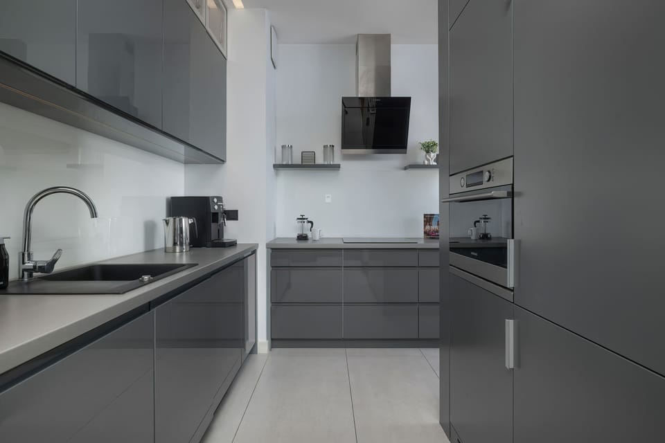 Sleek kitchen in gray tones with built-in appliances and minimalist style.
