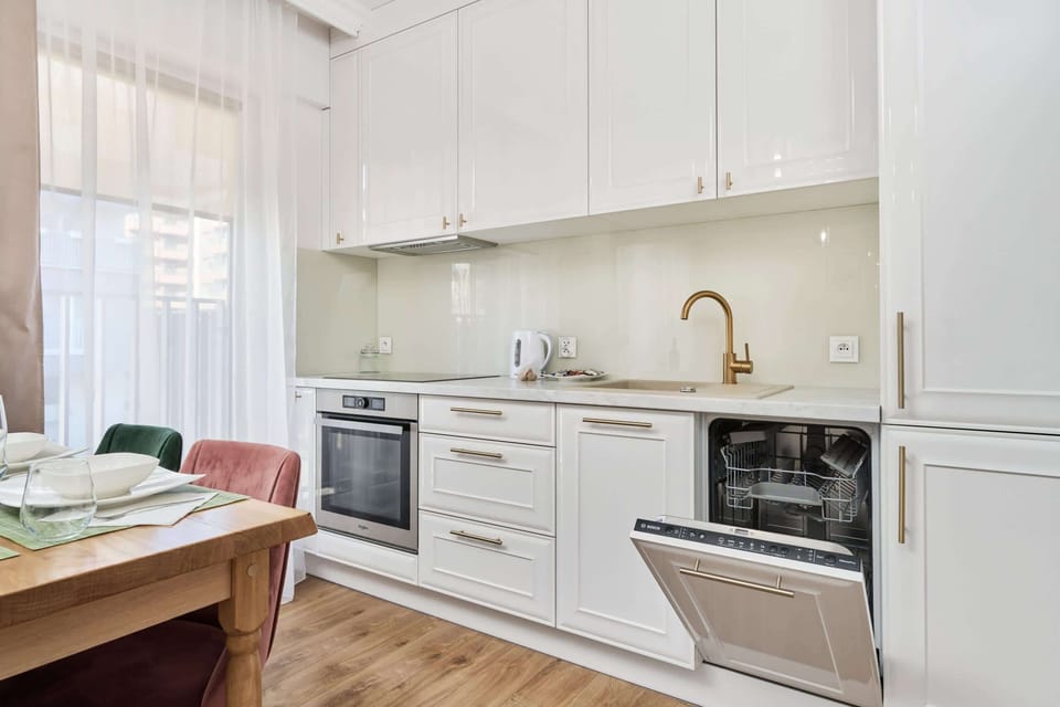 Another perspective of the kitchen showcasing its white cabinetry and clean, modern design.