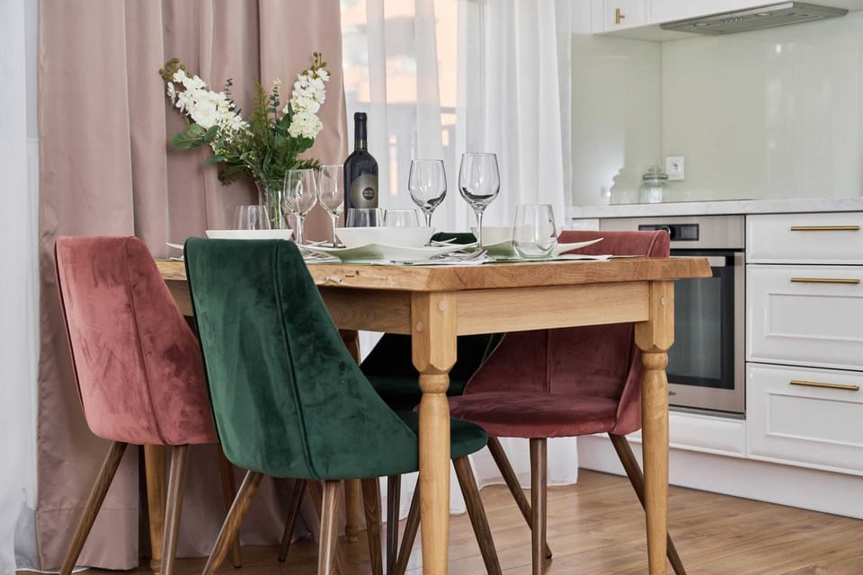 A small dining table set for two, with elegant wine glasses and greenery adding charm. The setting overlooks the kitchen.