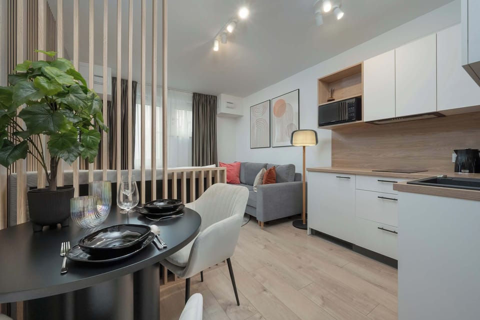Another view of the dining and kitchen area, highlighting the cohesive design with white cabinetry and warm wooden elements.

