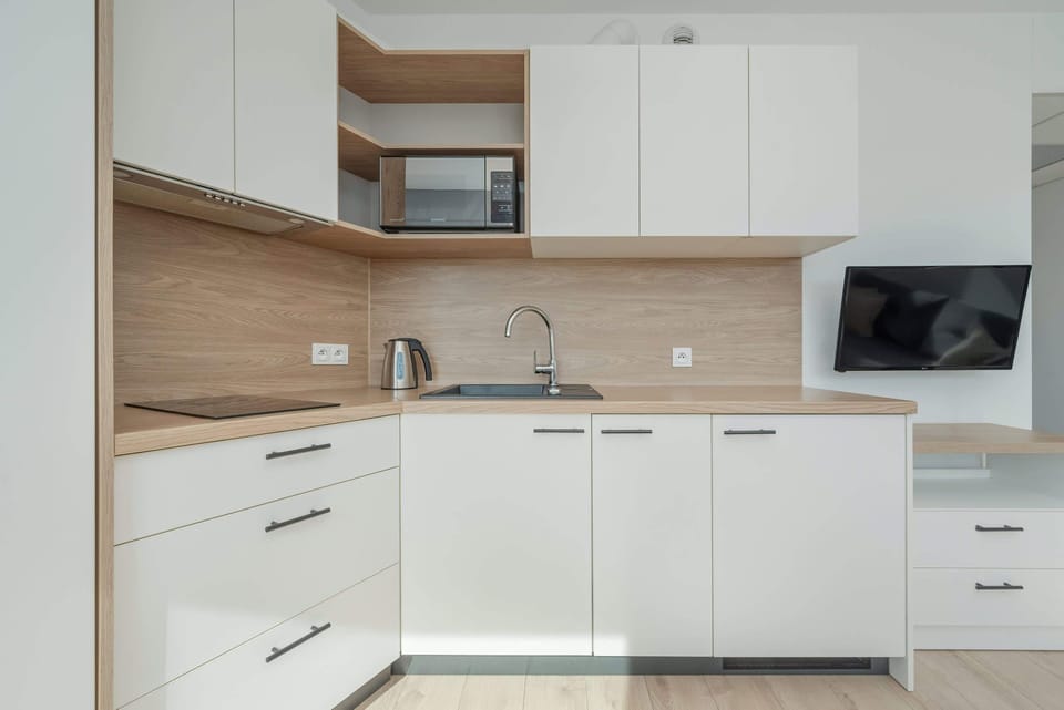 A wide view of the living room and kitchen, highlighting the open space concept. The combination of modern furniture and neutral tones creates a harmonious, cozy atmosphere.