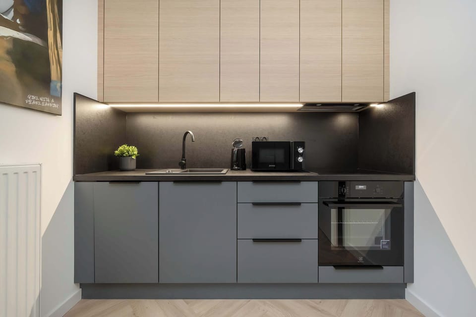 Fully equipped kitchen with induction hob, oven, microwave, refrigerator with freezer, electric kettle, coffee maker and dishwasher.
