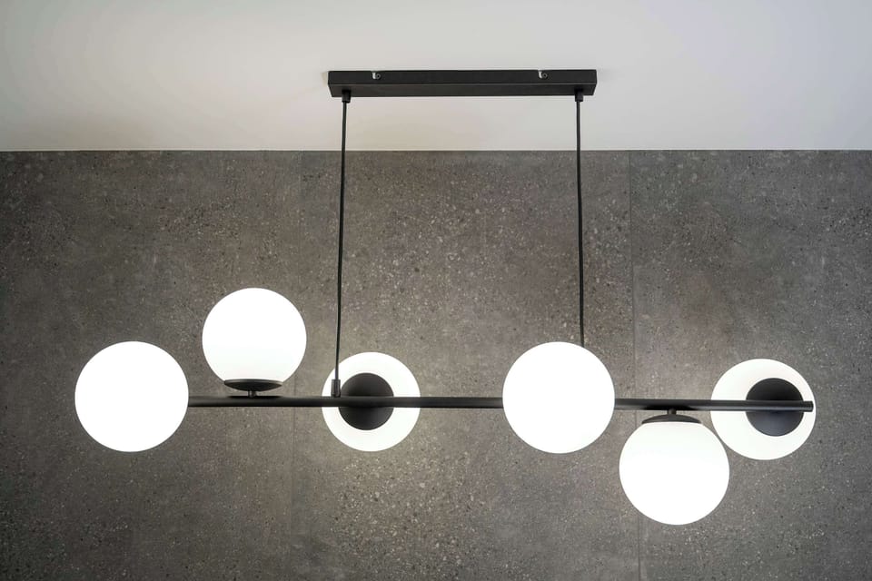A close-up of a modern chandelier hanging in the bathroom, adding a touch of sophistication.