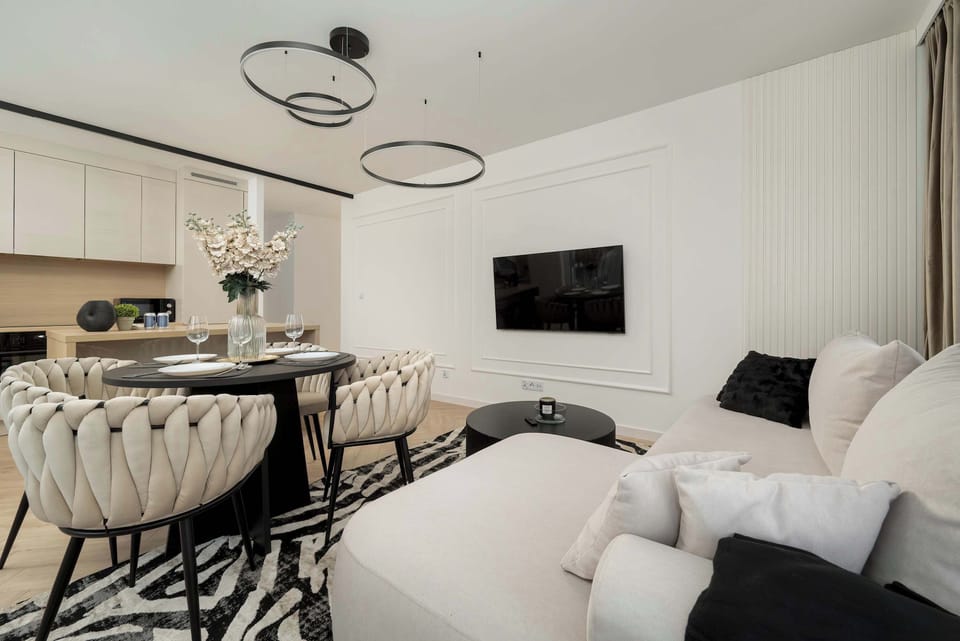 Another view of the dining area with a round table and upholstered chairs. The adjacent sofa adds to the cohesive design.