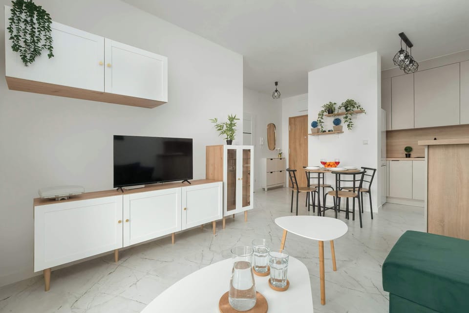 A cozy living room with a green sofa and a wall-mounted TV, perfect for relaxing evenings. The modern décor adds a stylish touch.