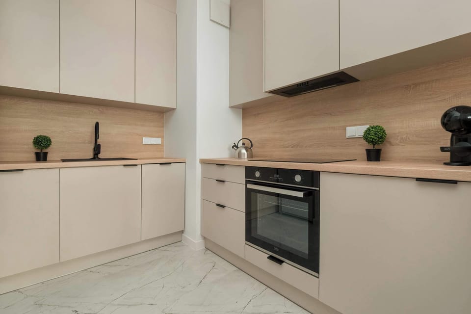 A compact and modern kitchen with clean lines, featuring a built-in oven and a functional worktop. Ideal for preparing meals with ease.