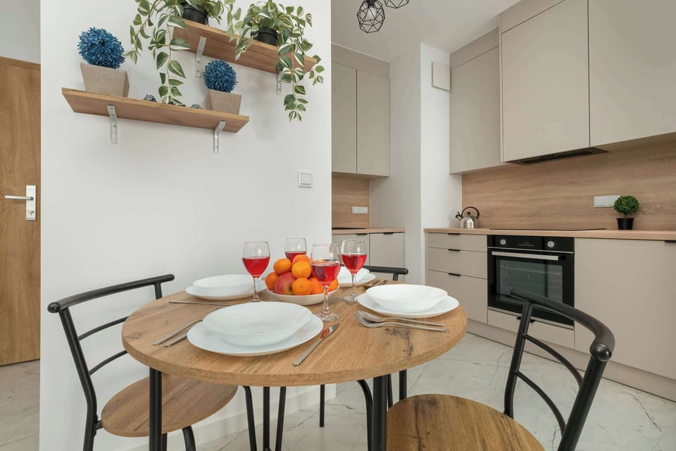 A round dining table set for four, ideal for enjoying meals or working comfortably. Positioned near a bright window for natural light.

