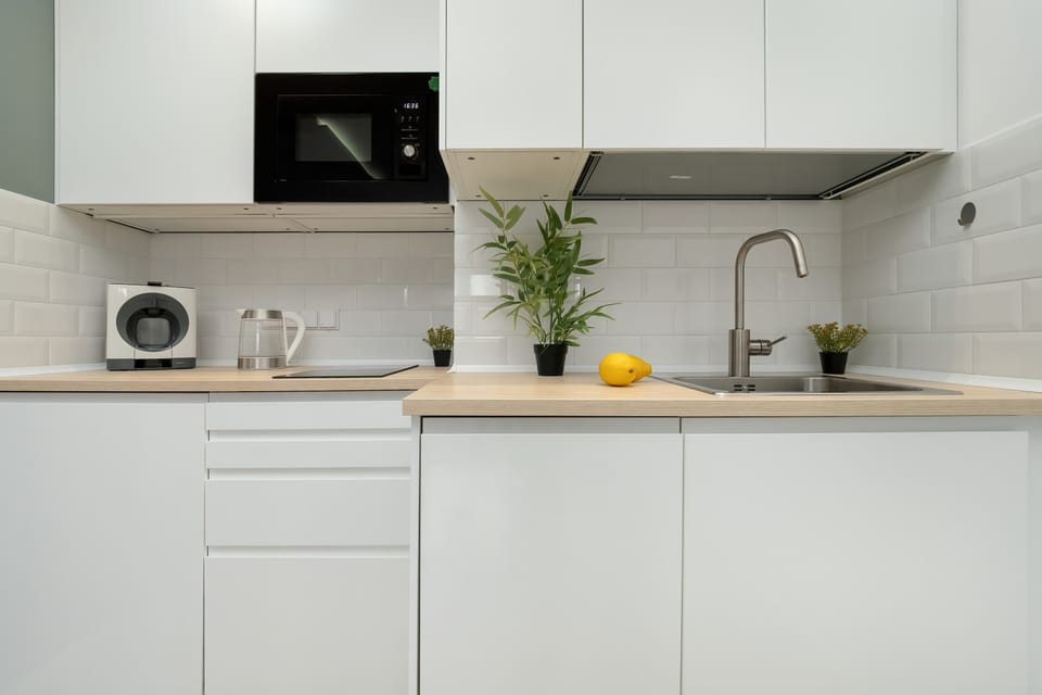 White cabinetry and a wooden countertop create a harmonious, modern blend.