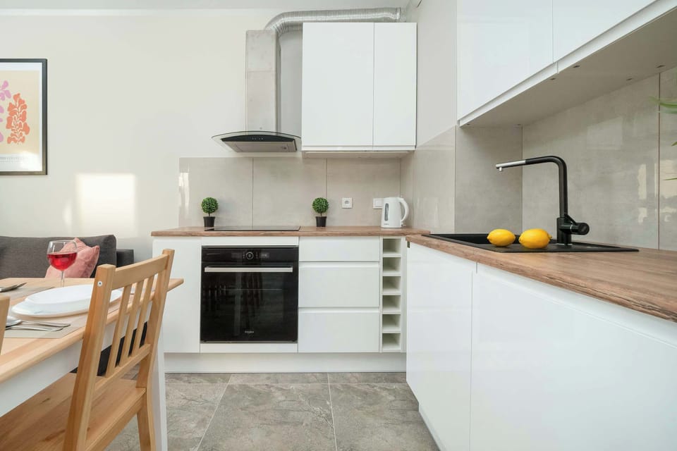 The kitchen has sleek cabinetry and modern appliances, including a stove and oven, with a minimalist and functional design perfect for cooking.