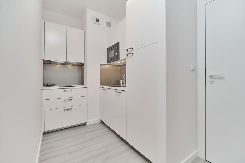 White furniture and high quality equipment that will have the possibility of preparation of home meals.