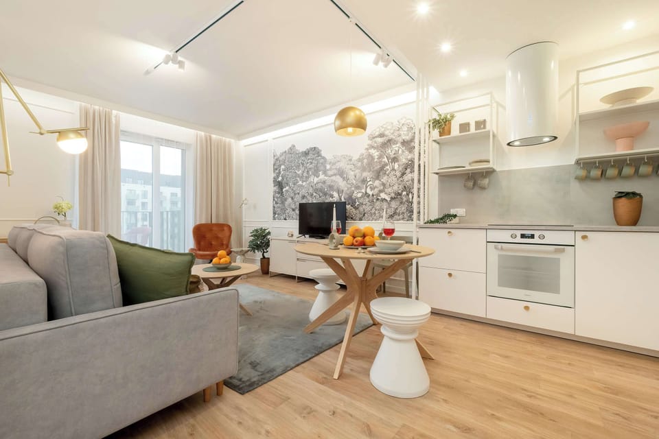 This living room has a comfortable sofa, round coffee table, and warm light from ceiling fixtures, creating an inviting environment.
