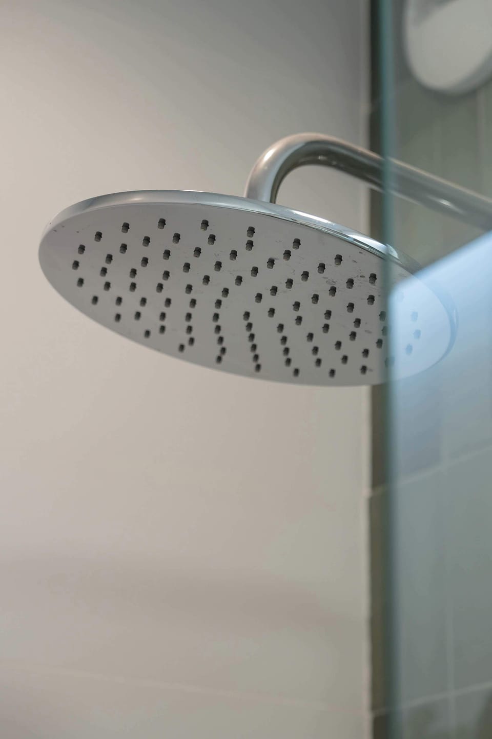 A close-up of a modern shower with a rainfall showerhead, giving the bathroom a luxurious feel.