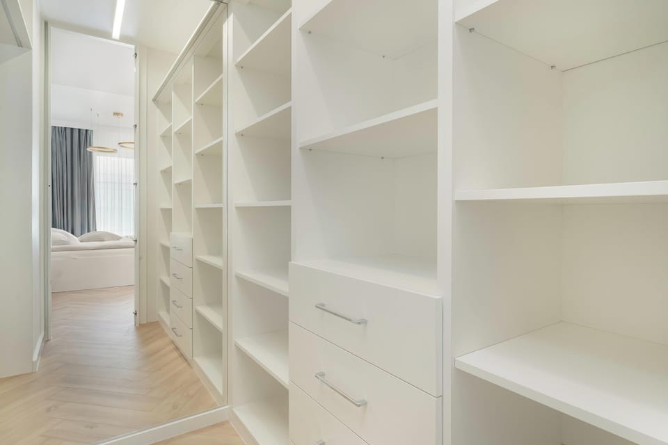 A well-organized walk-in closet with plenty of shelving and drawers, providing ample storage for clothes and accessories.
