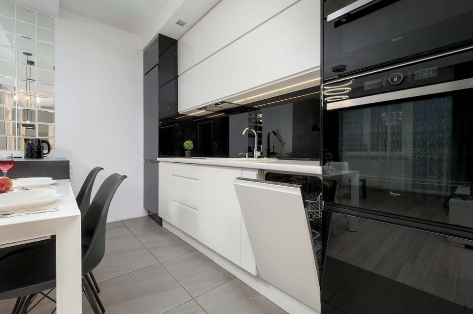 Fully equipped kitchenette with induction cooktop, oven, electric kettle, refrigerator with freezer, microwave and dishwasher.