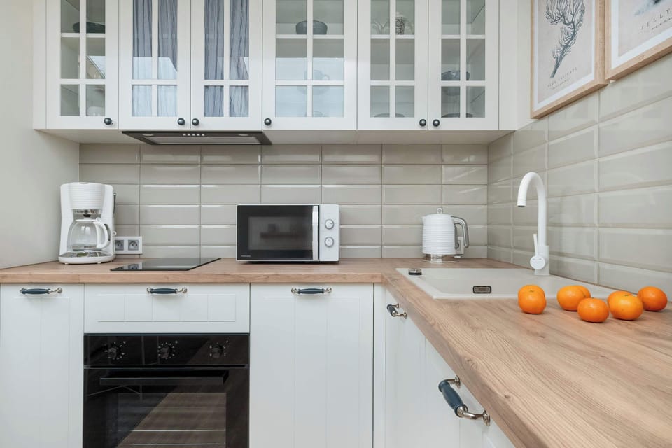 A closer look at the modern kitchen, showcasing the microwave, cabinets, and countertop space.