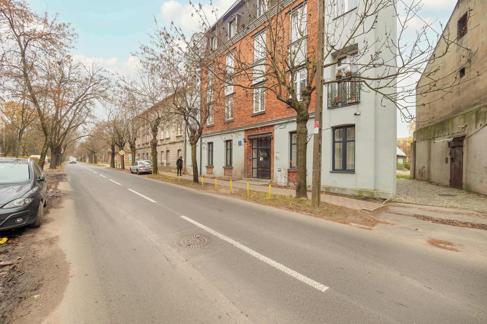 A further street view showing quiet surroundings, residential buildings, and trees.
