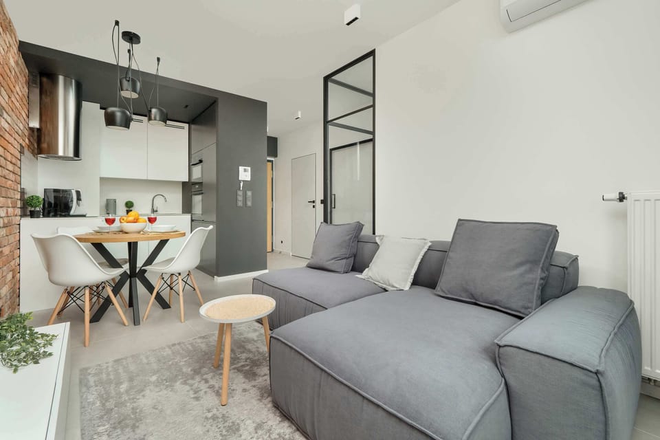 Elegant and atmospheric living room with dining table, television, grey sofa, and coffee table.