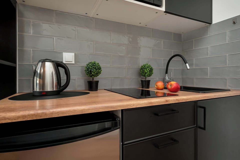A close-up of the modern kitchen with dark cabinets, wooden countertops, and minimalistic decor.