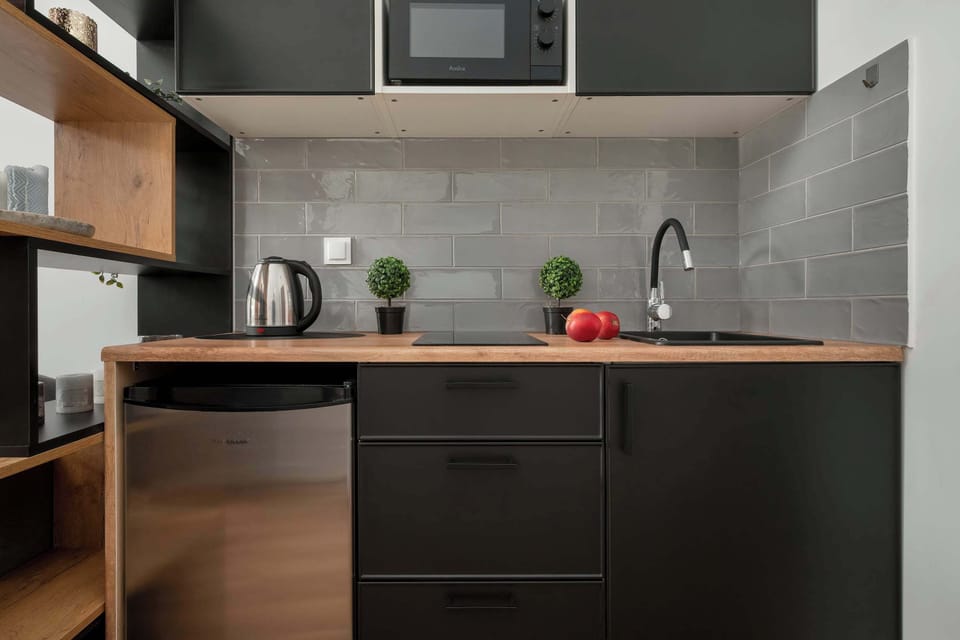 A close-up of the modern kitchen with dark cabinets, wooden countertops, and minimalistic decor.
