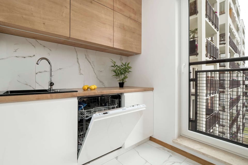 Kitchenette with built-in dishwasher and cabinets – Sleek, fully equipped cooking area.