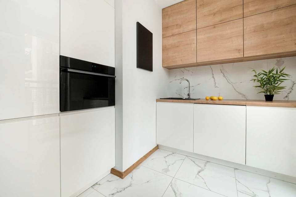 White kitchen cabinetry with wood accents – Simple and practical with clean finishes.