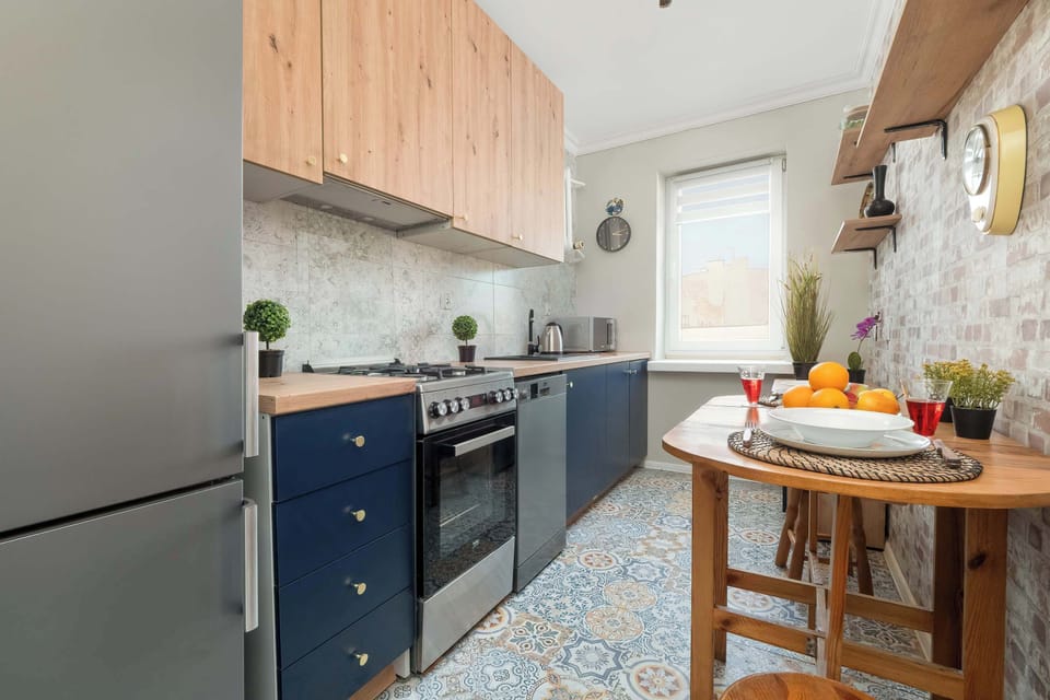  Close-up of the kitchen counter with a gas stove, wooden countertop, and navy-blue cabinets.
