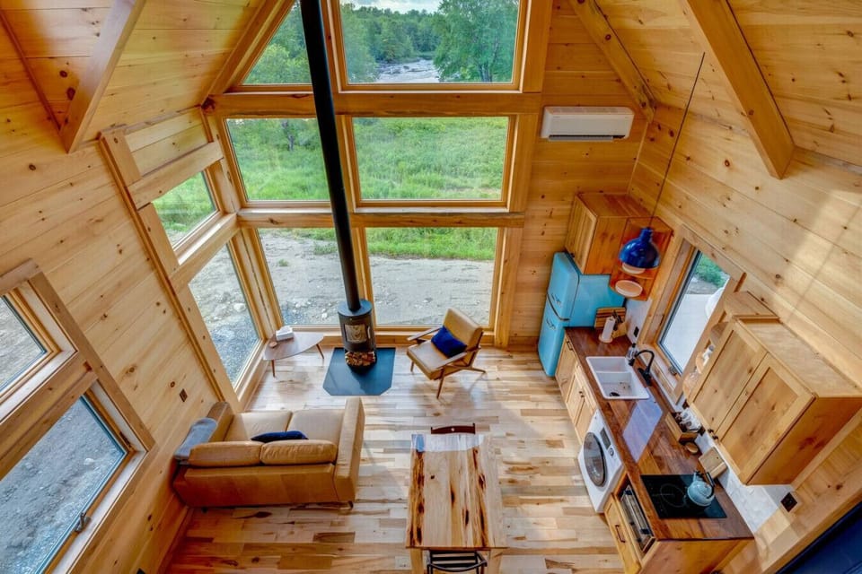 View from the loft at Willow: a tall wall of windows, warm wood, and the Union River just beyond.