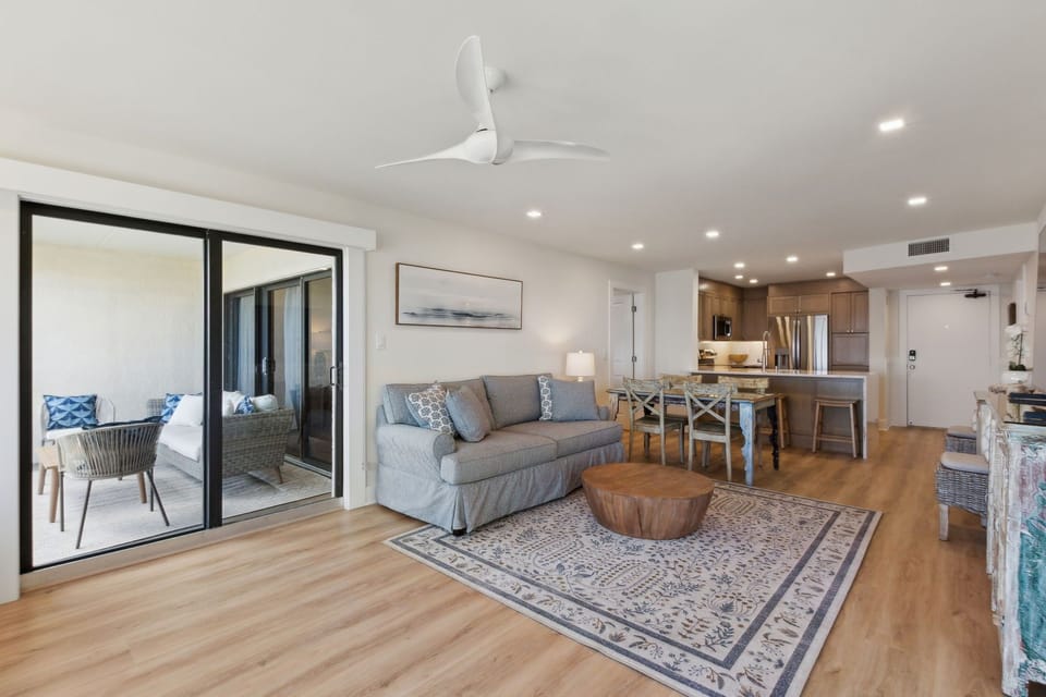 Relaxing Living Area Featuring Plush Couch and Chairs, Flat Screen Smart TV, and Modern Coastal Decor
