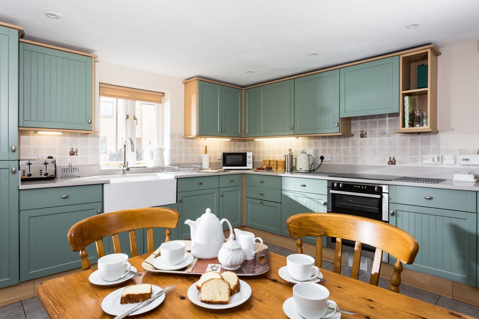 Breakfast kitchen with a double oven and induction hob, dishwasher and table, perfect for enjoying a leisurely breakfast