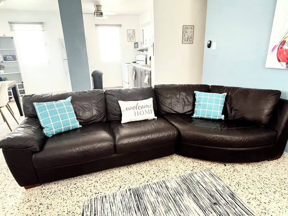 The living room is bright and airy with large, comfy sofa, and  Smart TV