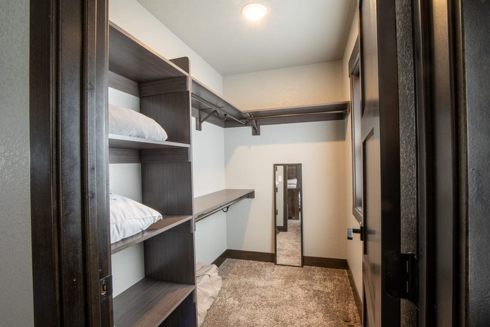 Unpack and settle in—this spacious walk-in closet off the king ensuite makes it easy to stay organized, with plenty of room for your wardrobe and gear.