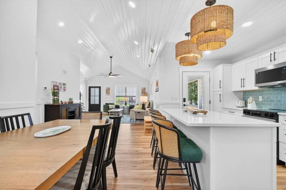 The open-concept living space is highlighted by soaring cathedral ceilings, creating a bright and spacious atmosphere that connects the kitchen, dining, and living areas.