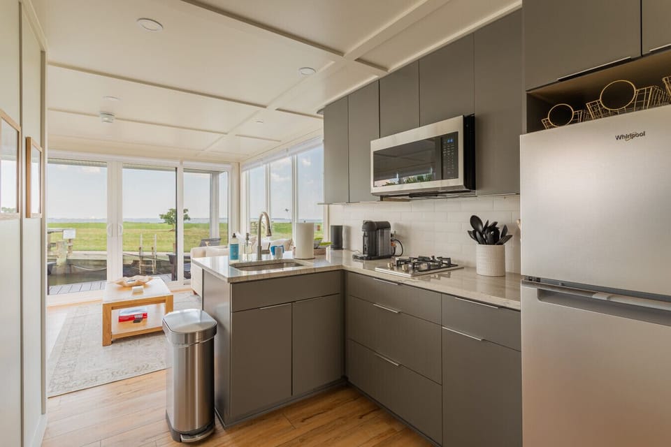 Hallway view through the galley kitchen to the sliding doors, framing the Chesapeake Bay horizon straight ahead.