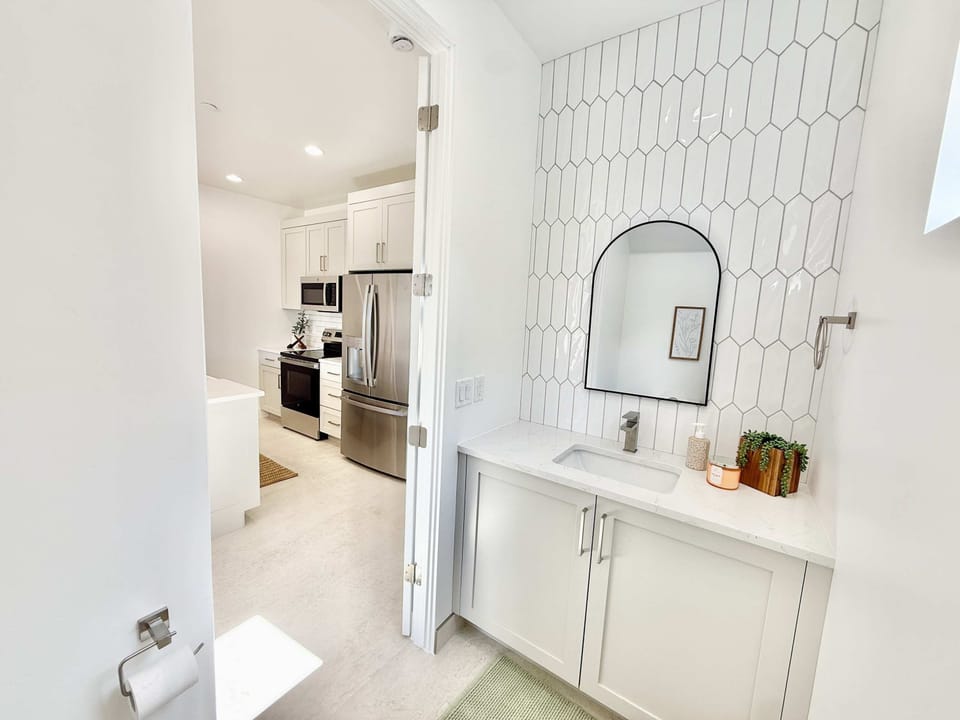 Sleek half bathroom with designer touches is located just off the kitchen on the main level for your convenience