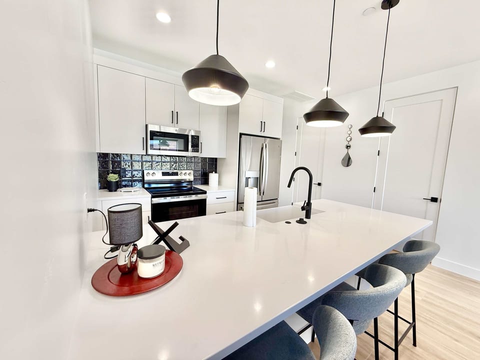 Fully stocked luxury kitchen with stainless appliances, island seating & sleek finishes
