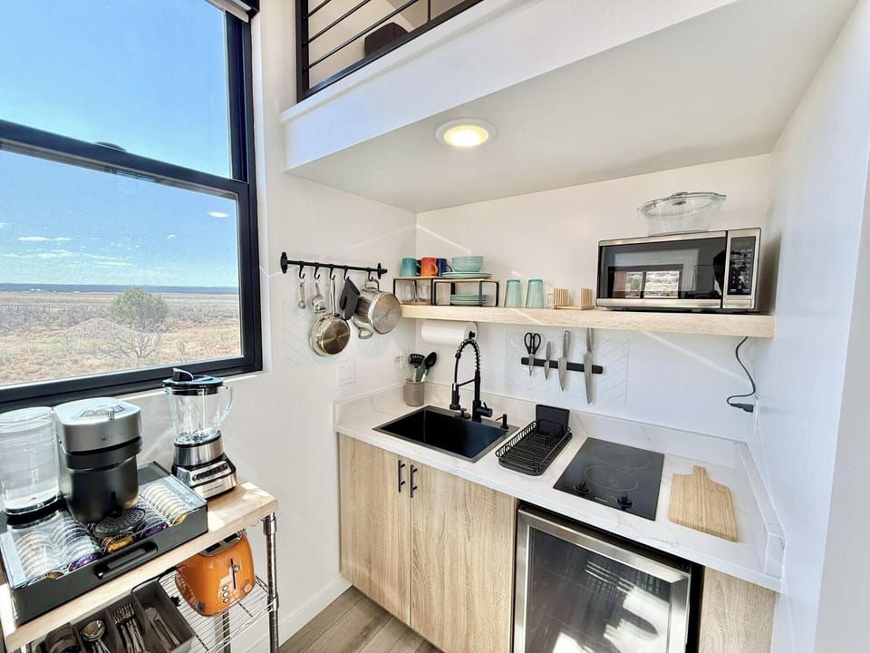 Compact kitchenette with open shelving, cooktop, and sweeping desert views—Journey Pines, Kanab UT.