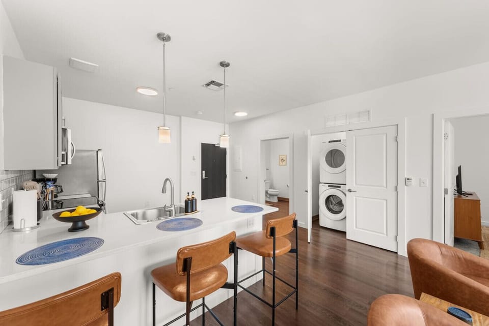 Fully equipped kitchen with quartz countertops, stainless steel appliances, and bar seating