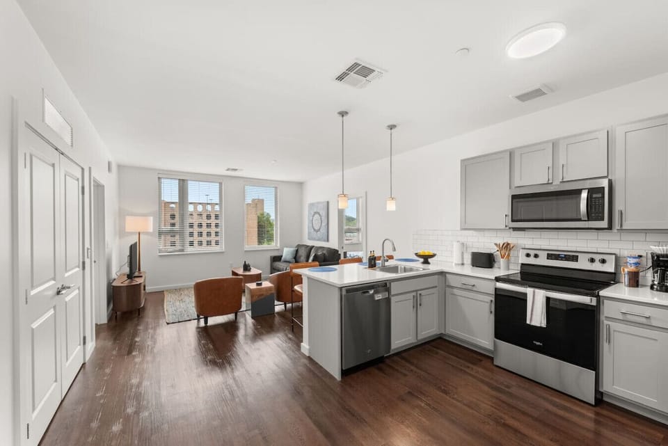Open-concept living and kitchen area with Smart TV and quartz island