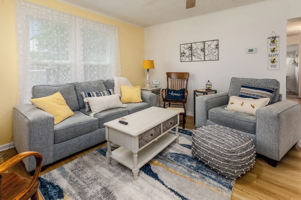 This cheerful living room is filled with honey-hued touches, cozy seating for everyone, and a 32" smart TV for your favorite shows. Whether you're sipping coffee, reading by the bookcase, or relaxing in a rocker—this space is bee-yond cozy!